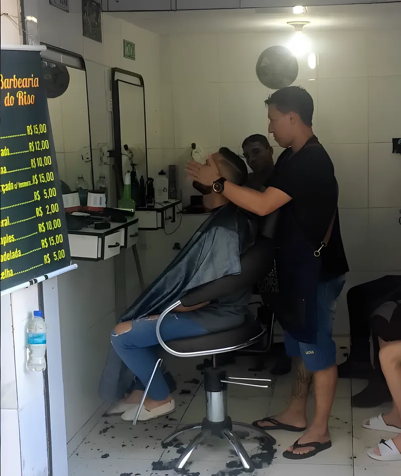 Cliente sendo atendido na Barbearia do Riso — corte de cabelo no centro do Rio de Janeiro